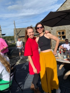 a photo of Ellie and Rebeka smiling outside on a sunny day